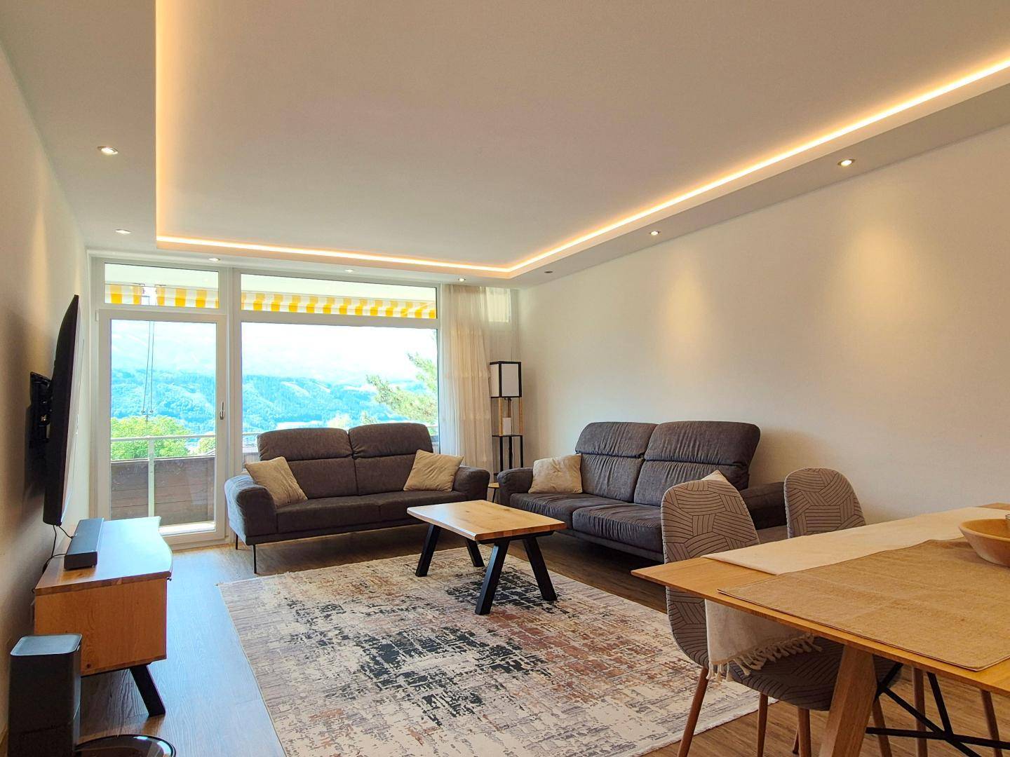 Gemütlicher Wohnbereich mit zwei Sofas, Couchtisch und weitem Blick auf die umliegende Berglandschaft.
