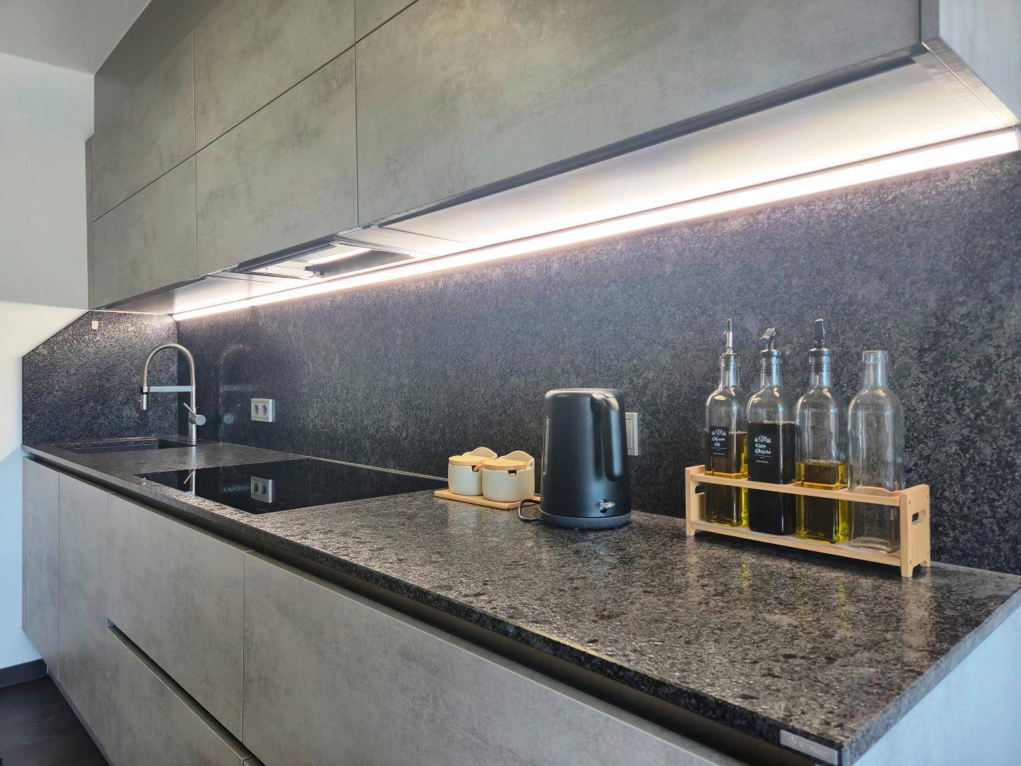 Elegante Küchenarbeitsplatte mit integriertem Spülbecken und modernem Induktionskochfeld für effizientes Kochen.