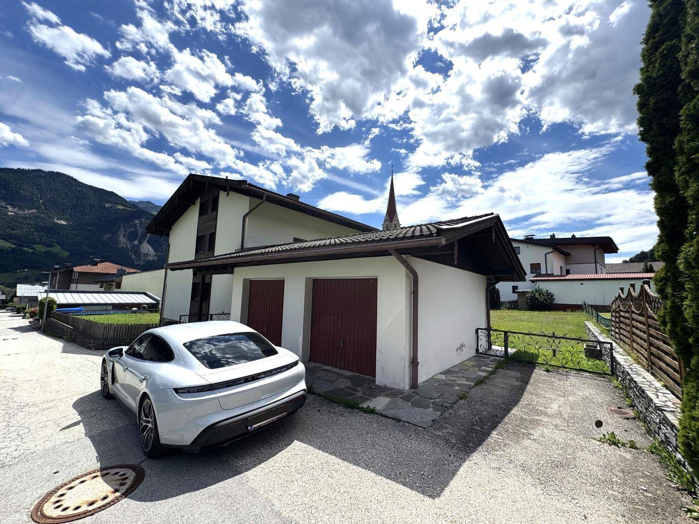 Ansicht des Hauses mit Doppelgarage und einem modernen Auto auf der Zufahrt.