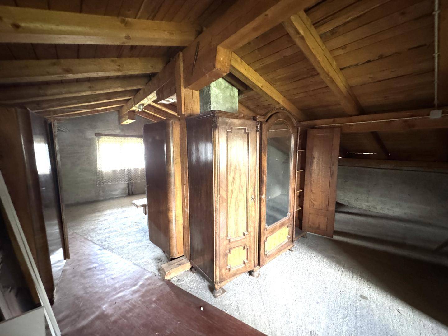 Geräumiger Dachboden mit alten Holzschränken und sichtbarer Dachkonstruktion.