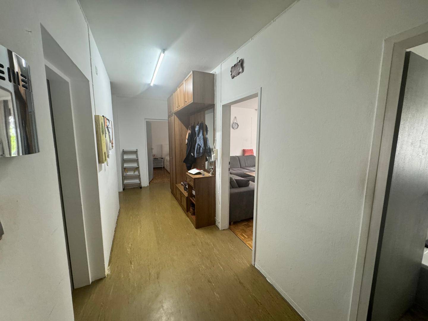 Heller Flur mit praktischem Holzschrank, Garderobe und Zugang zu weiteren Räumen der Wohnung.