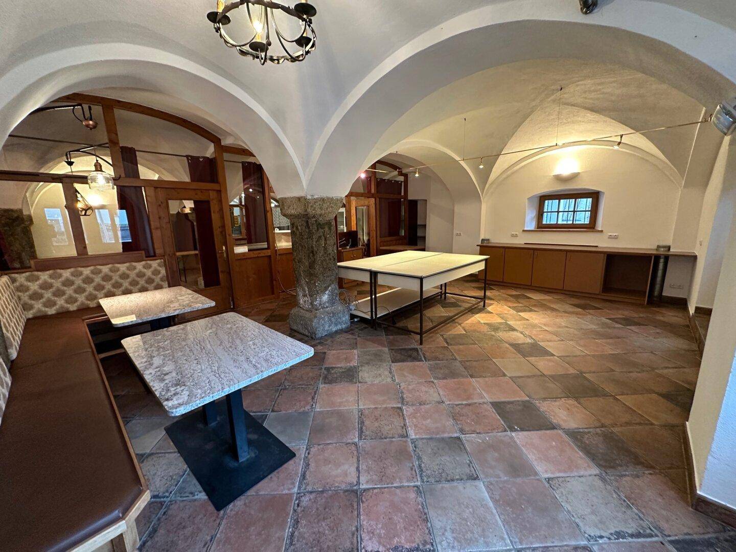 Rustikaler Bereich mit Terrakotta-Fliesenboden, Gewölbedecken und gemütlichen Sitzgelegenheiten, ideal für Gäste.