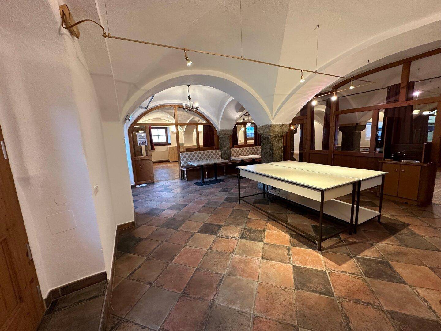 Historischer Innenraum mit Terrakotta-Fliesenboden, Gewölbedecken und traditionellen Holzelementen, einladend gestaltet.