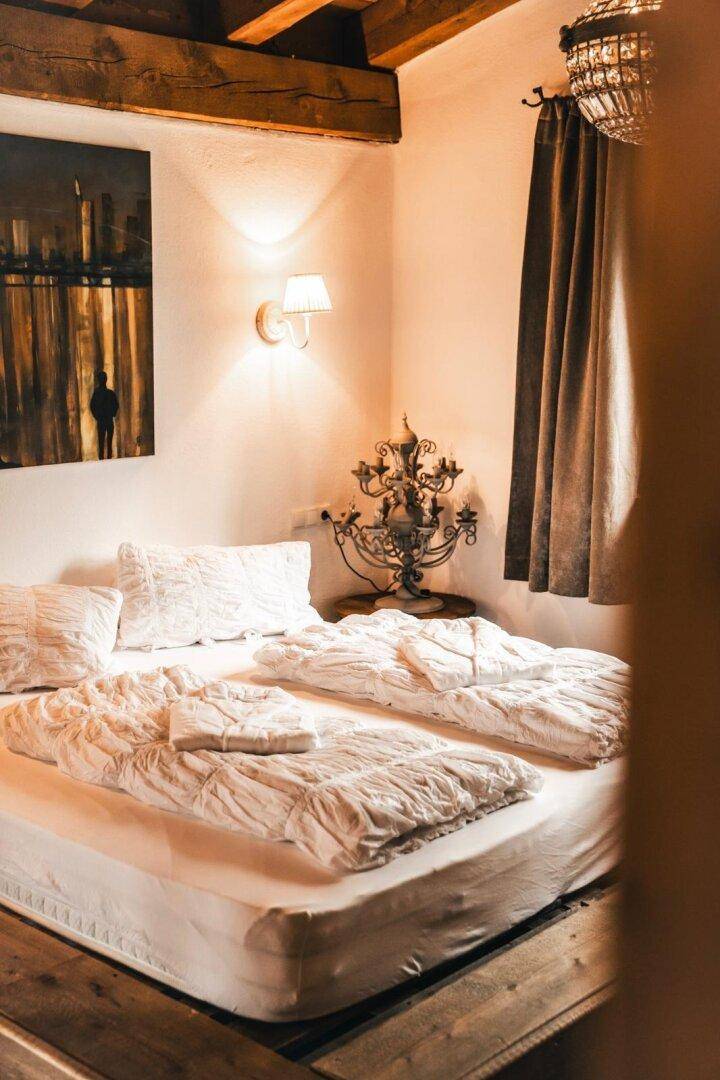 Gemütliches Schlafzimmer mit Doppelbett, Holzboden und indirekter Beleuchtung.