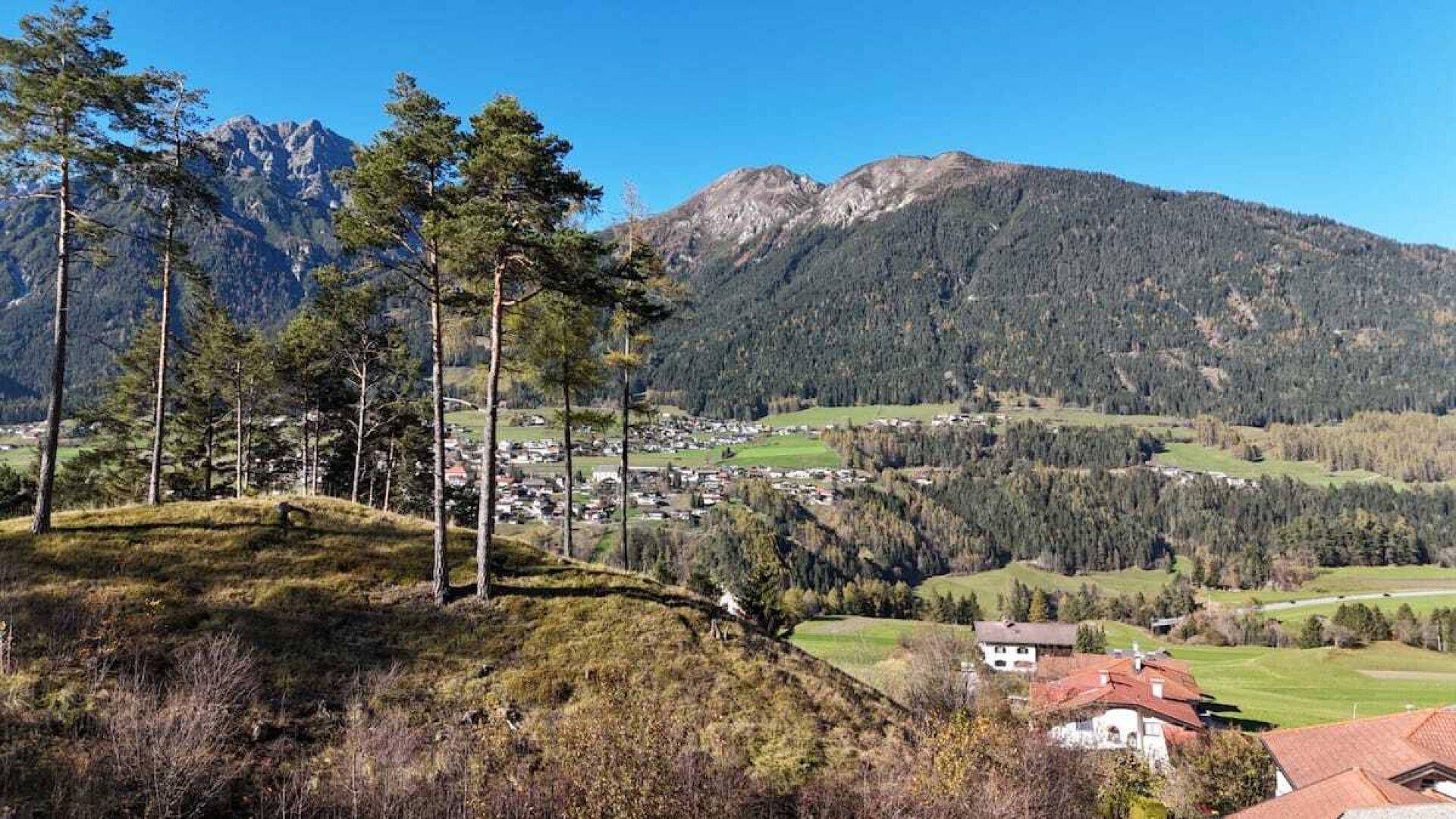 Panoramablick auf die umliegende Berglandschaft mit einem Dorf im Tal.
