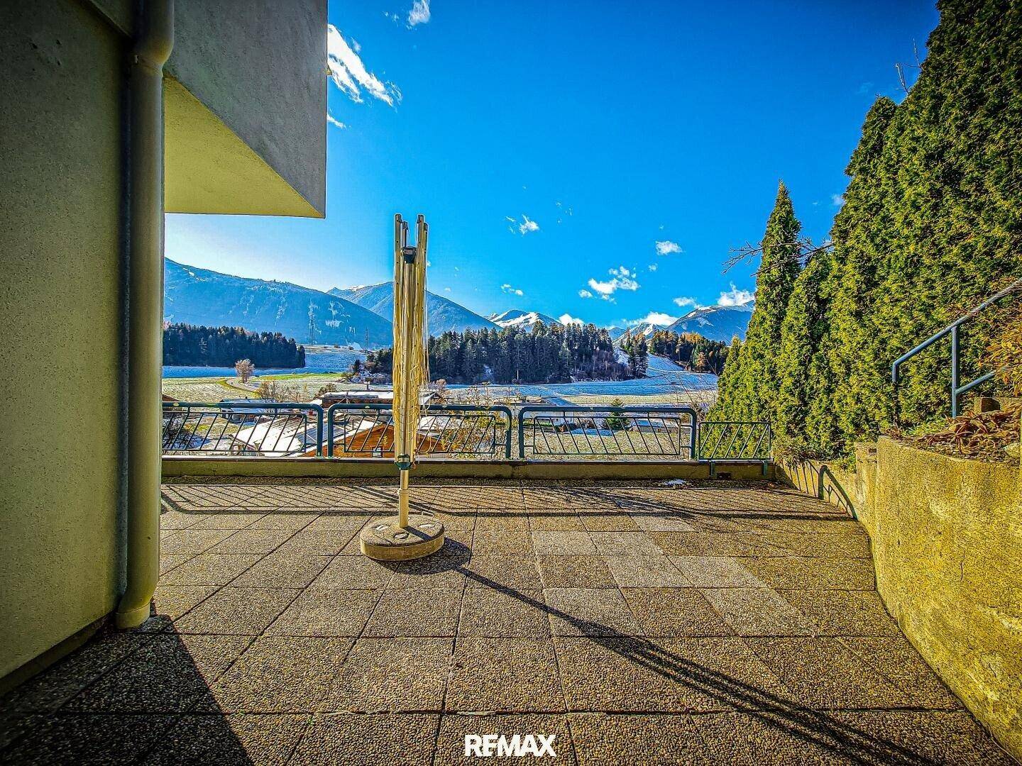 Große geflieste Terrasse mit Wäscheständer und weitem Bergblick.