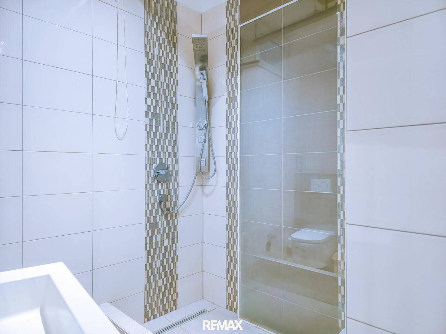 Duschbereich im Badezimmer mit modernen Fliesen und Glasabtrennung.