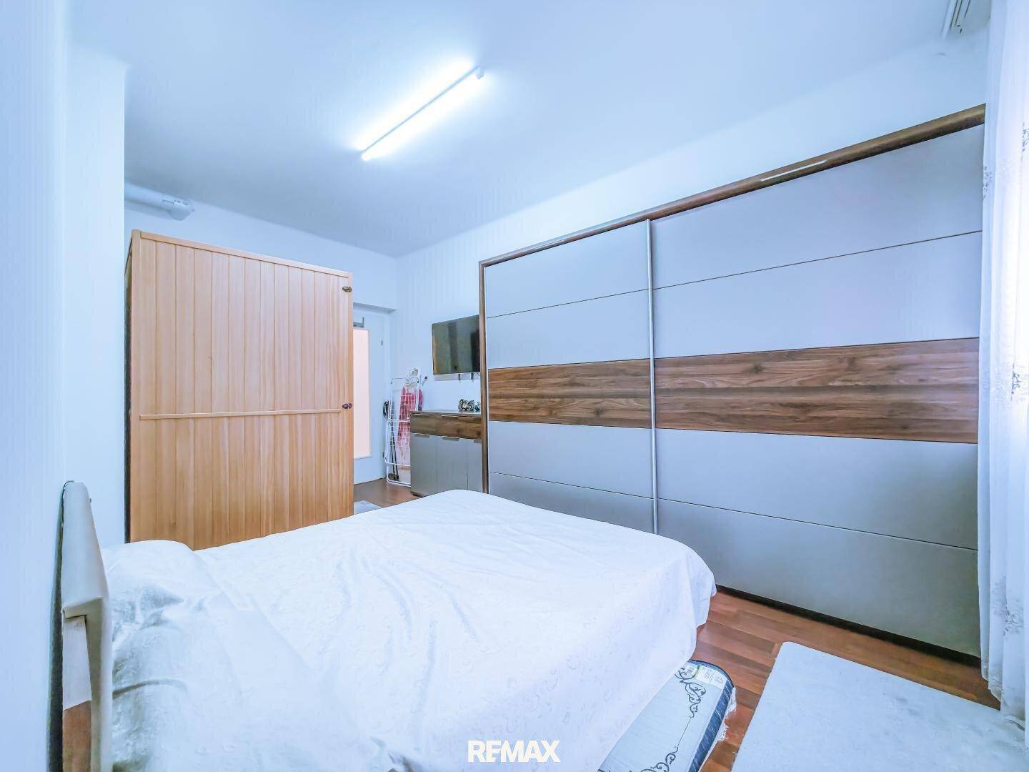 Schlafzimmer mit großem Schiebetürenschrank und Holzboden.