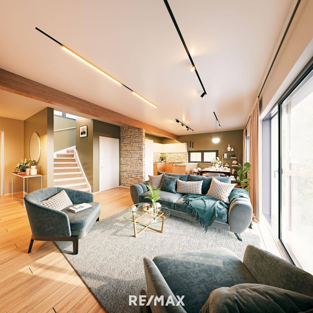 Moderner offener Wohn- und Essbereich mit Holzboden, bequemen Sofas und Blick auf die Treppe.