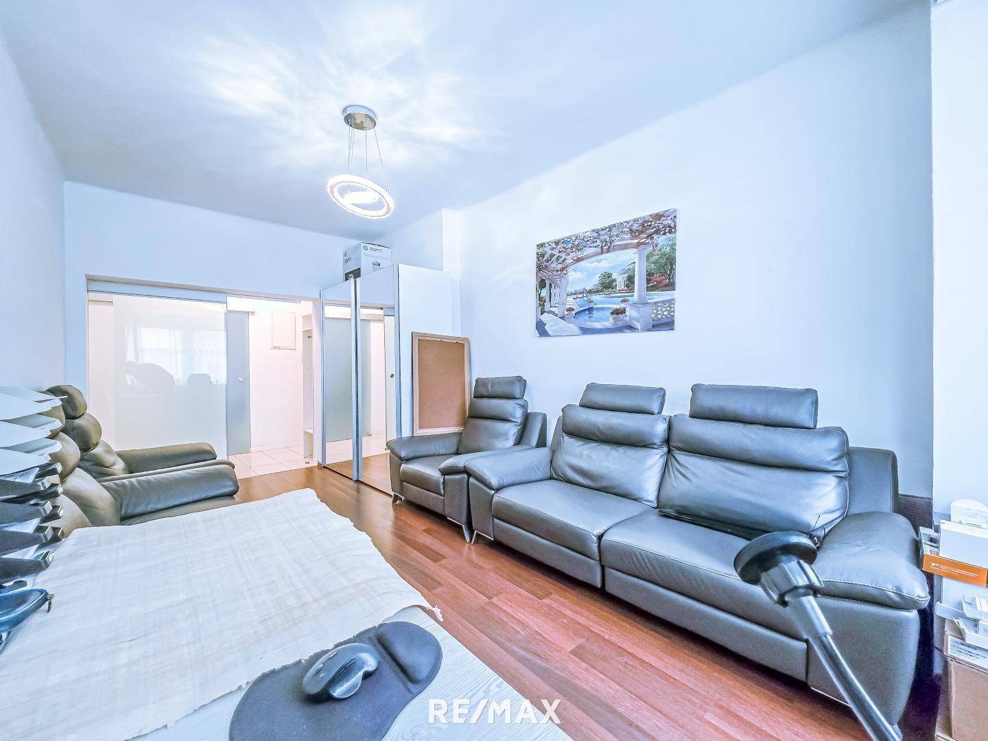 Büro mit mehreren Ledersofas und Holzboden.