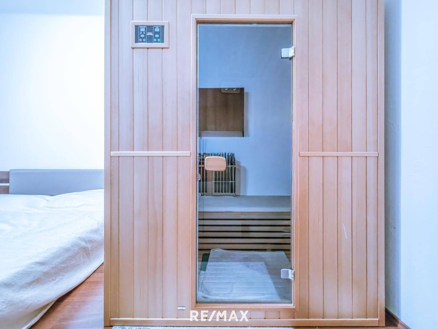 Moderne Sauna mit Holzausstattung und Glastür, integriert im Schlafzimmer.