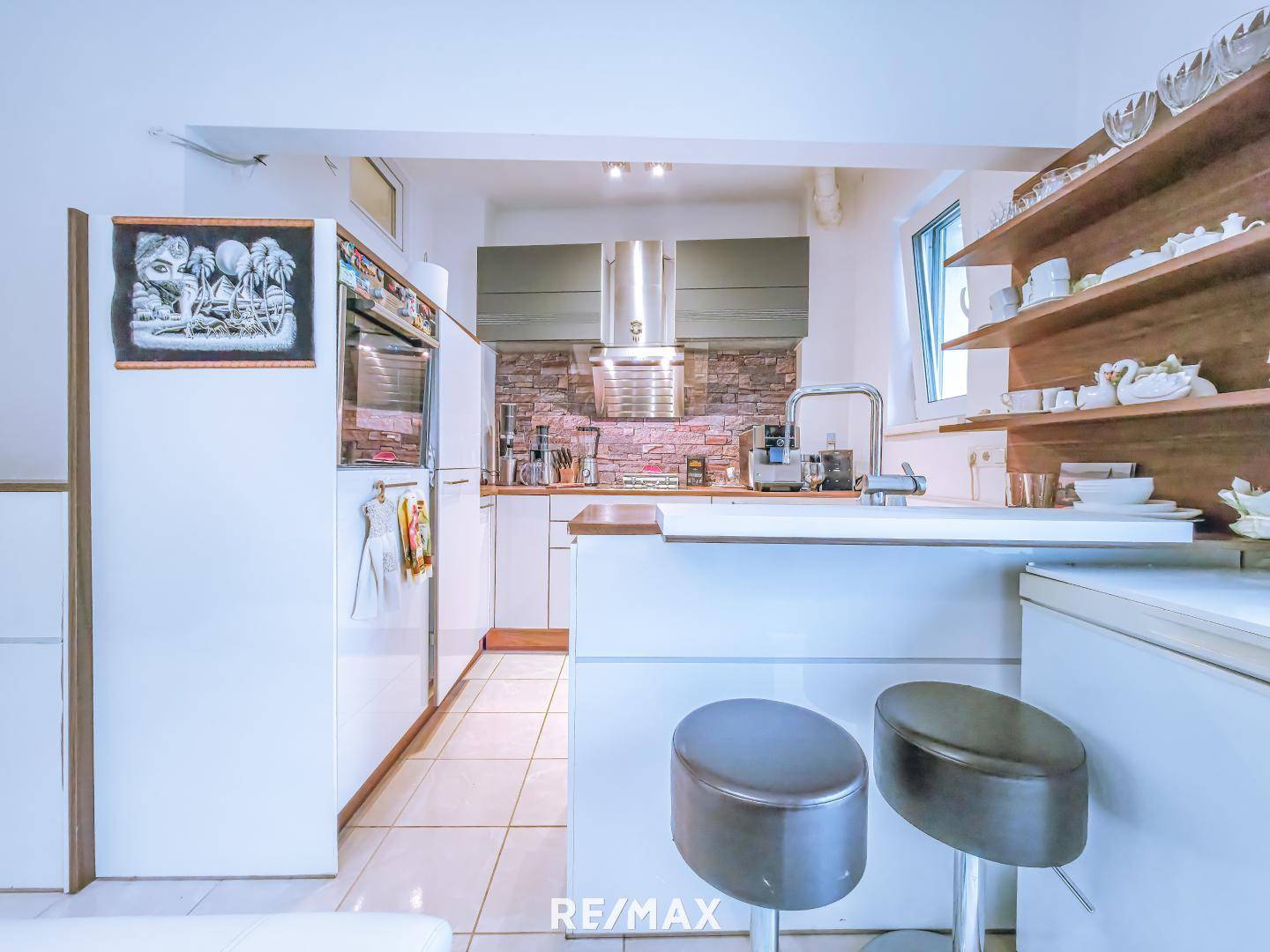 Funktionale Küche mit weißen Schränken, Backofen und Dunstabzugshaube.