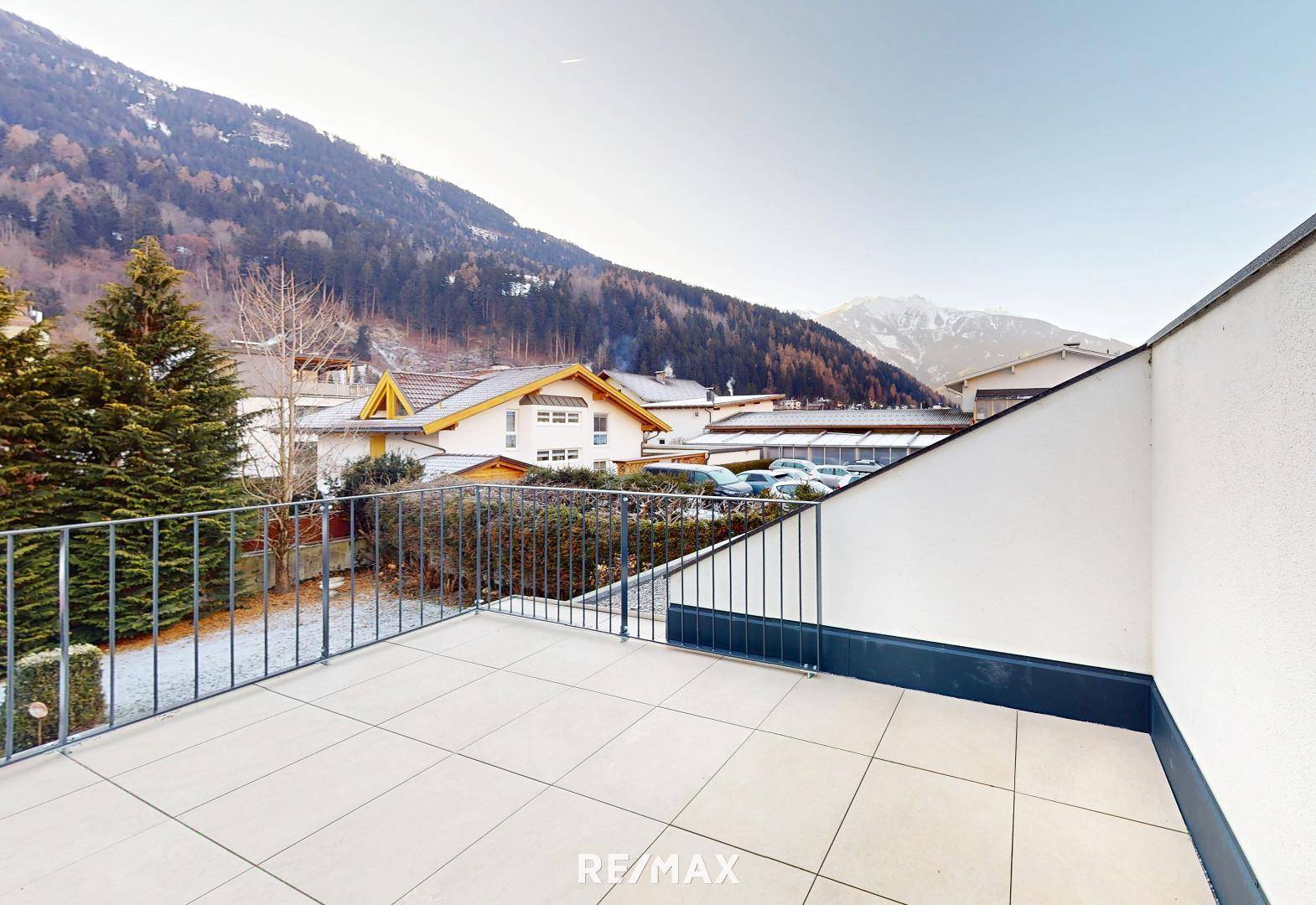 Geräumige Terrasse mit Fliesenboden und weitem Blick auf die Berglandschaft.