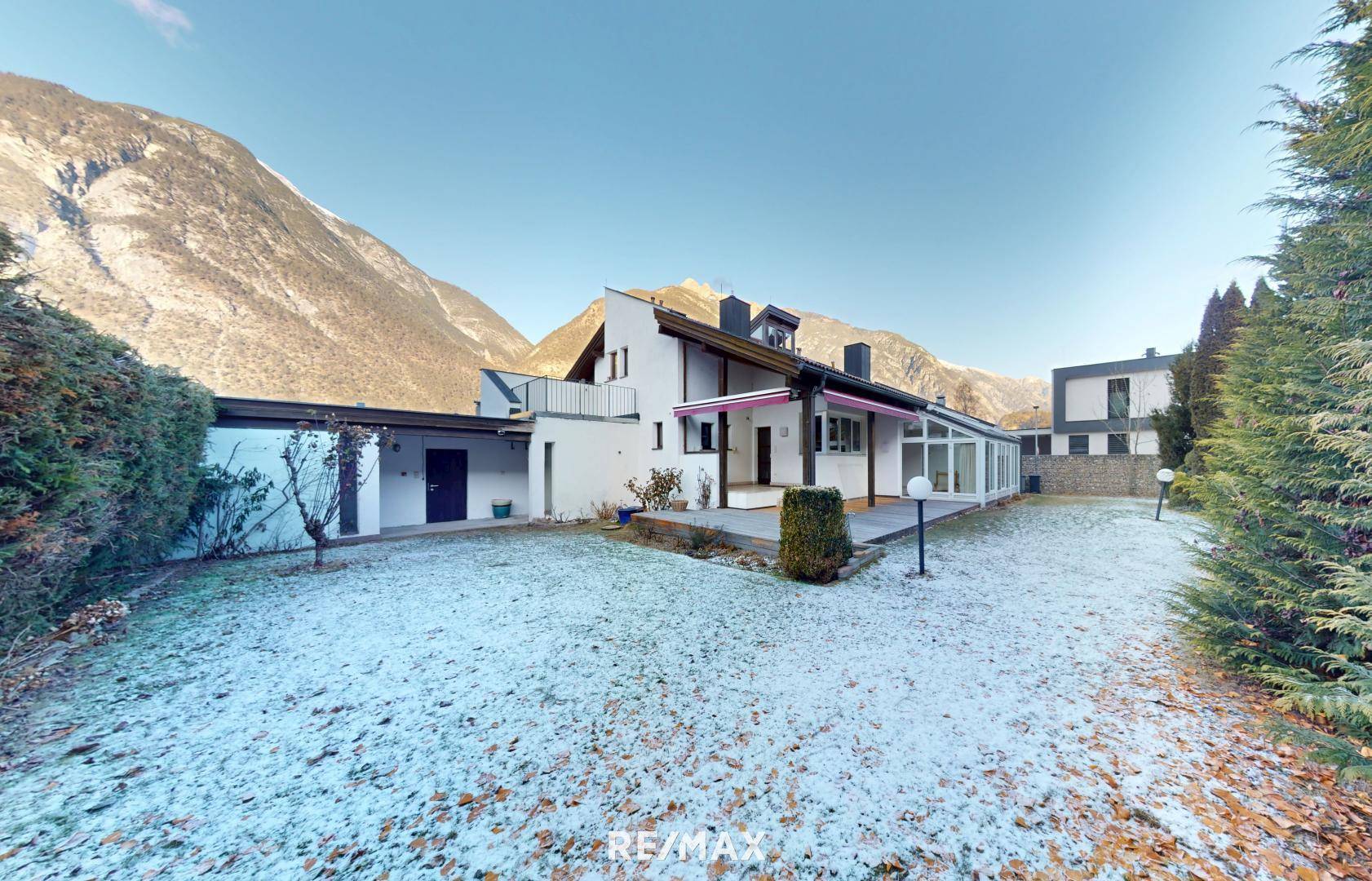 Außenansicht des Hauses mit Garten im Winter und Bergblick im Hintergrund.