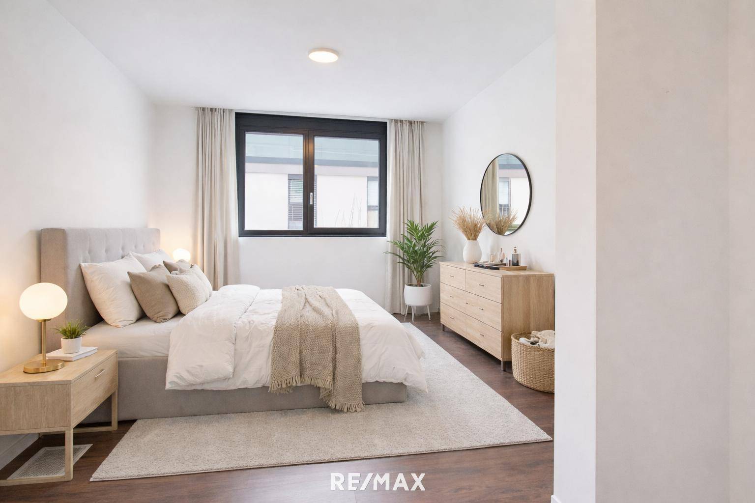 Gemütliches Schlafzimmer mit modernem Bett, Kommode und Teppich.