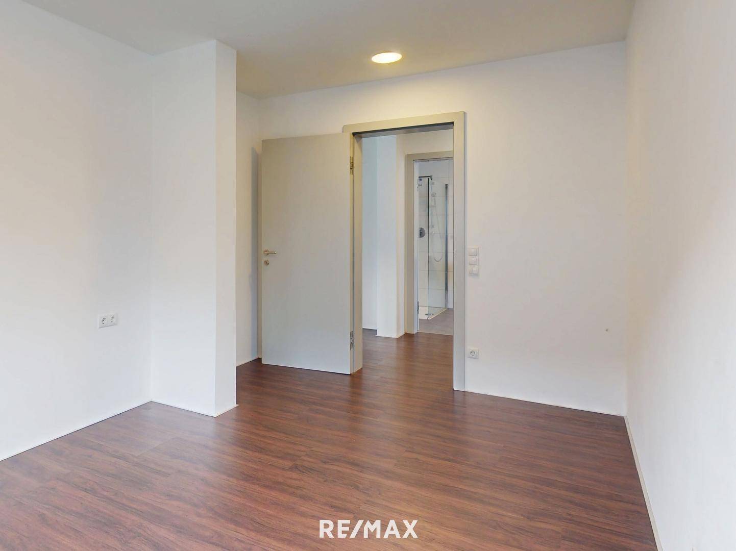 Heller Flurbereich mit Holzboden und Zugang zu weiteren Zimmern.