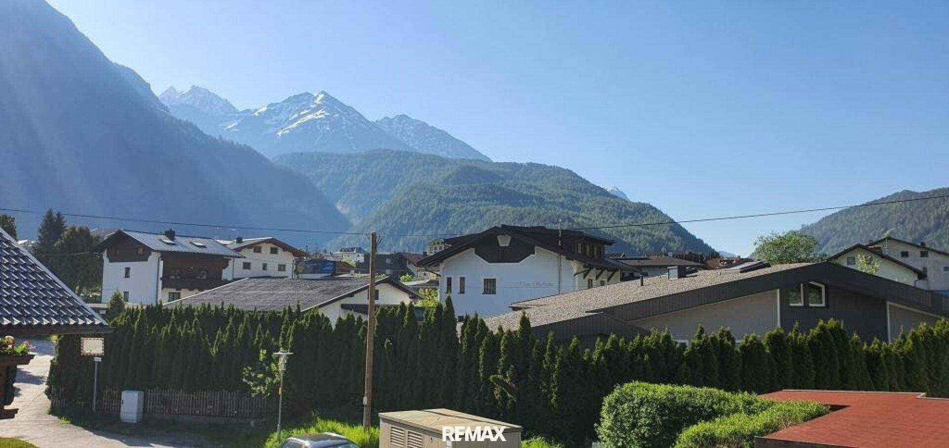 Panoramablick auf eine Wohnsiedlung vor der beeindruckenden Bergkulisse.