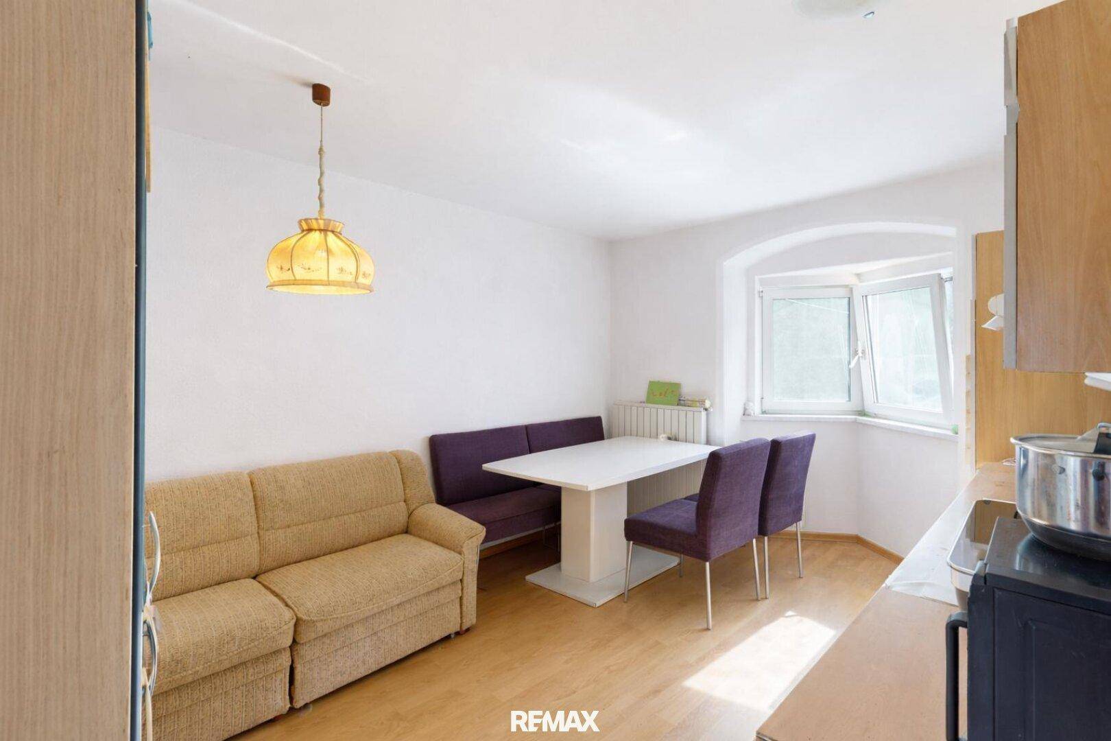 Gemütliche Küche mit Essbereich, Sofa und Fenster, perfekt für gemeinsame Mahlzeiten.