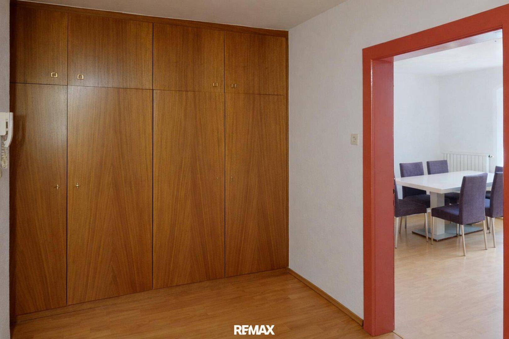 Flur mit großen Einbauschränken aus Holz und hellem Boden bietet viel Stauraum.
