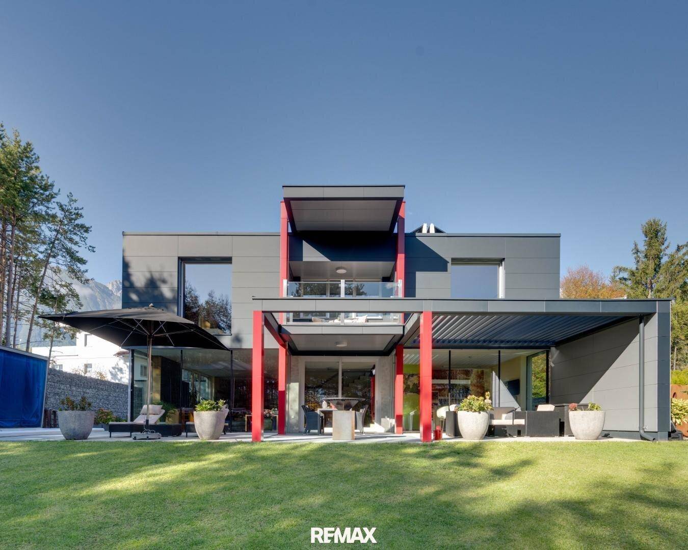 Frontansicht der modernen Villa mit gepflegtem Rasen und großzügigen Außenbereichen.