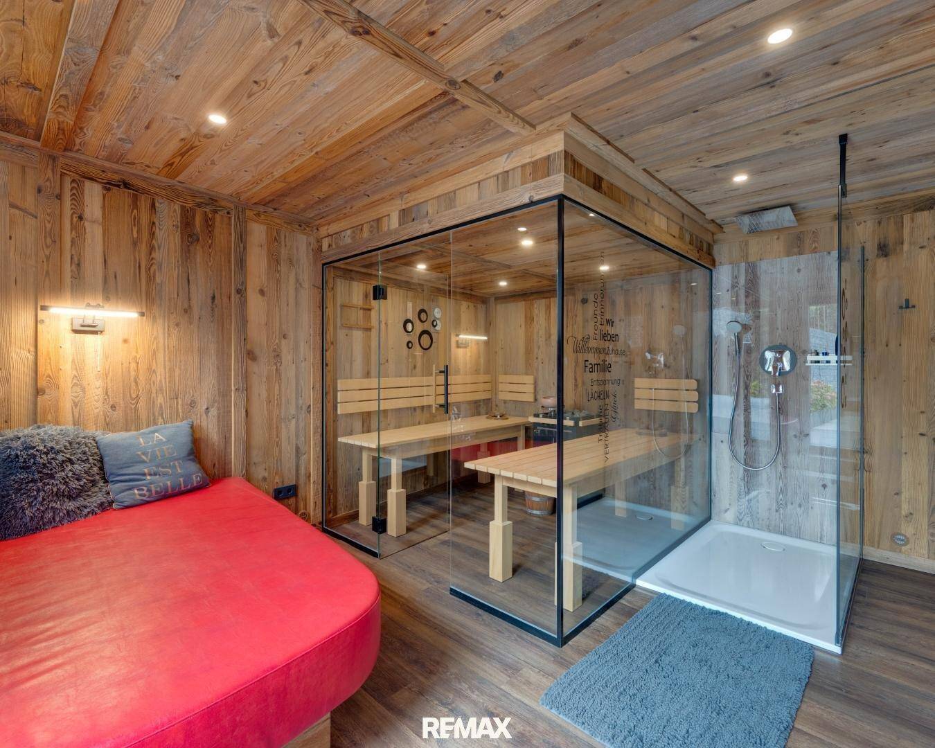 Gemütlicher Wellnessbereich mit Holzverkleidung, moderner Sauna und Dusche.