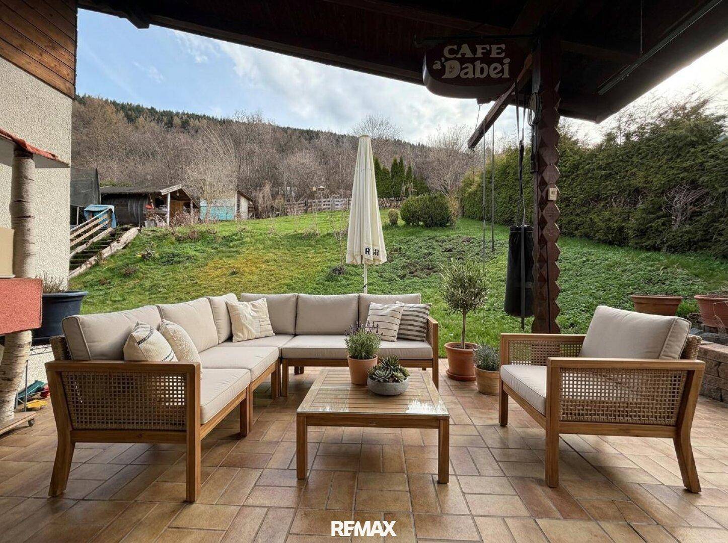 Möblierte Terrasse mit bequemen Loungemöbeln und Blick auf die umliegende Natur.