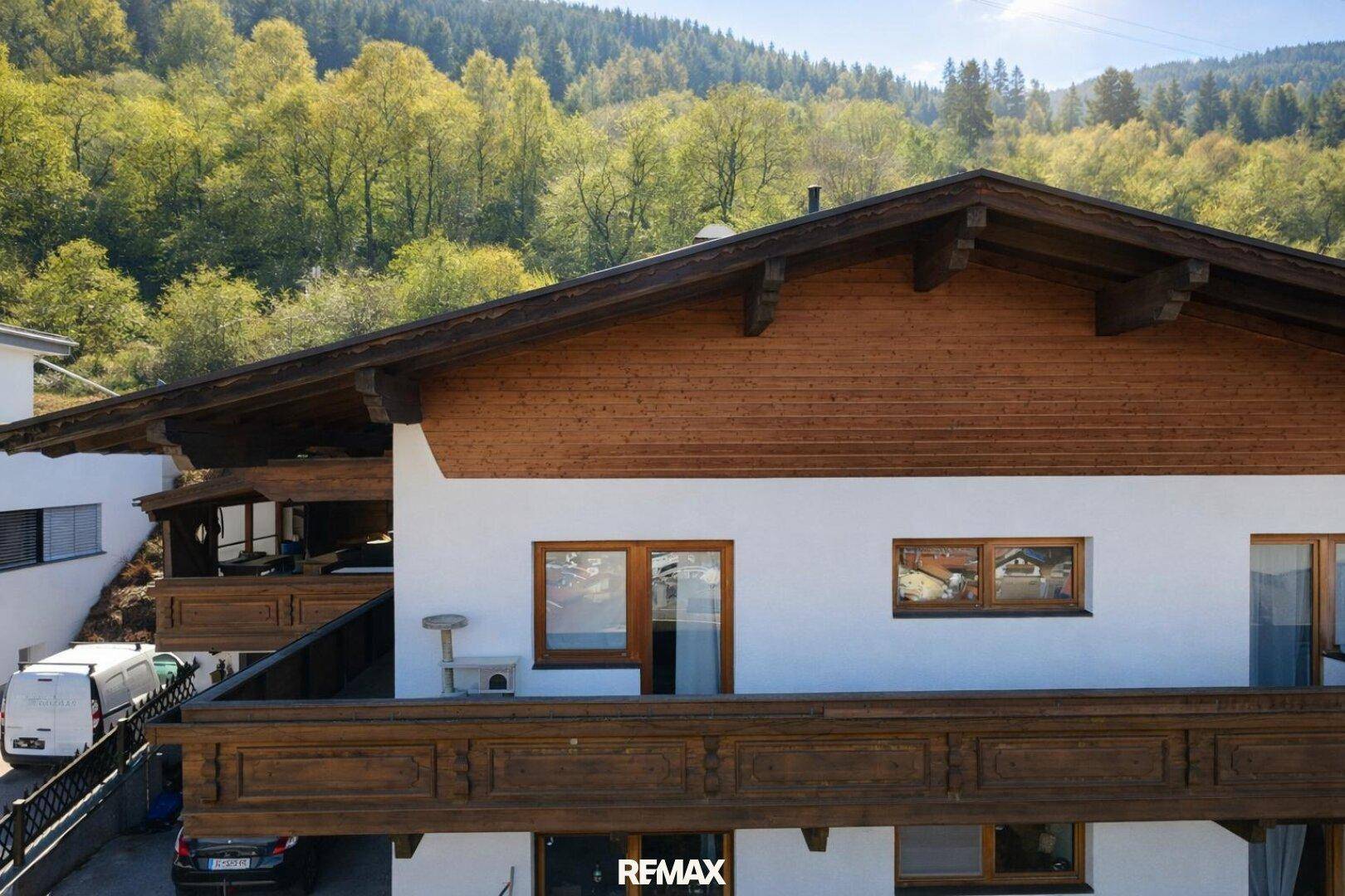 Detailansicht der Holzfassade und der traditionellen Balkone des Hauses mit Blick auf die Umgebung.