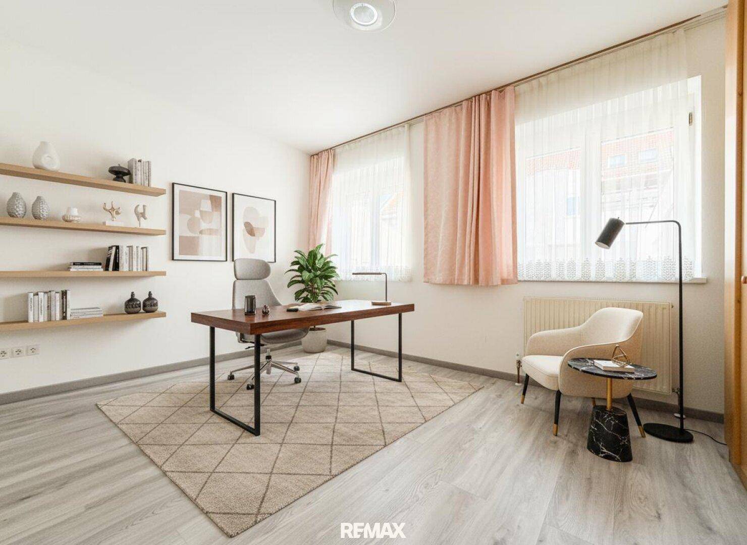 Helles Arbeitszimmer mit großem Schreibtisch, Regalen und zwei großen Fenstern.