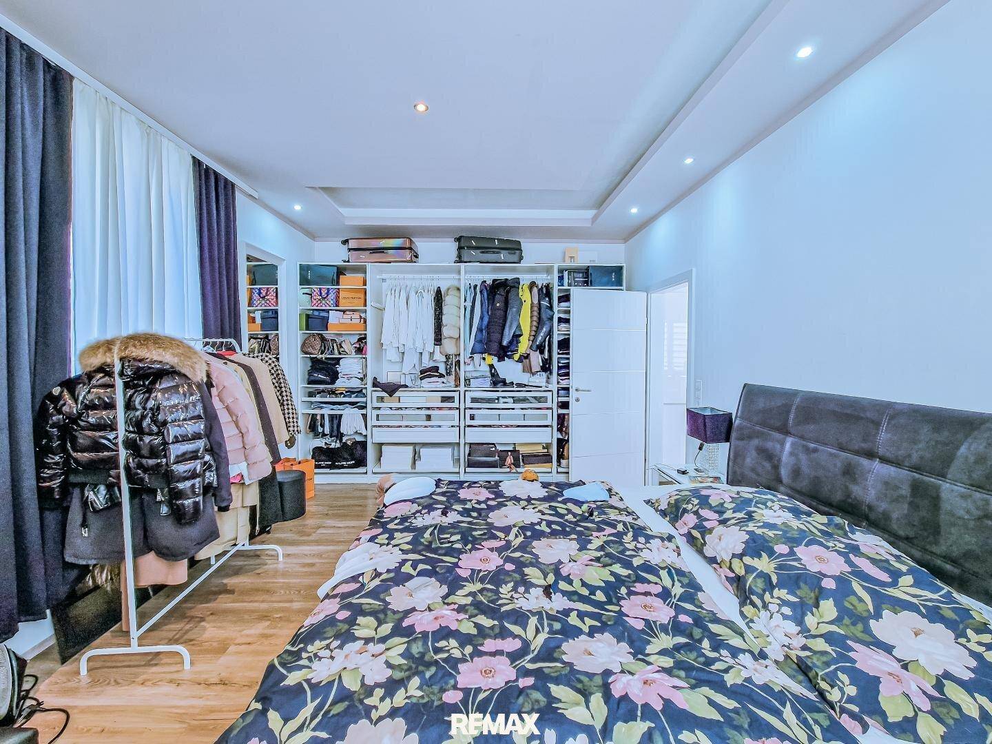 Geräumiges Schlafzimmer mit viel Stauraum durch offene Kleiderschränke und Doppelbett.