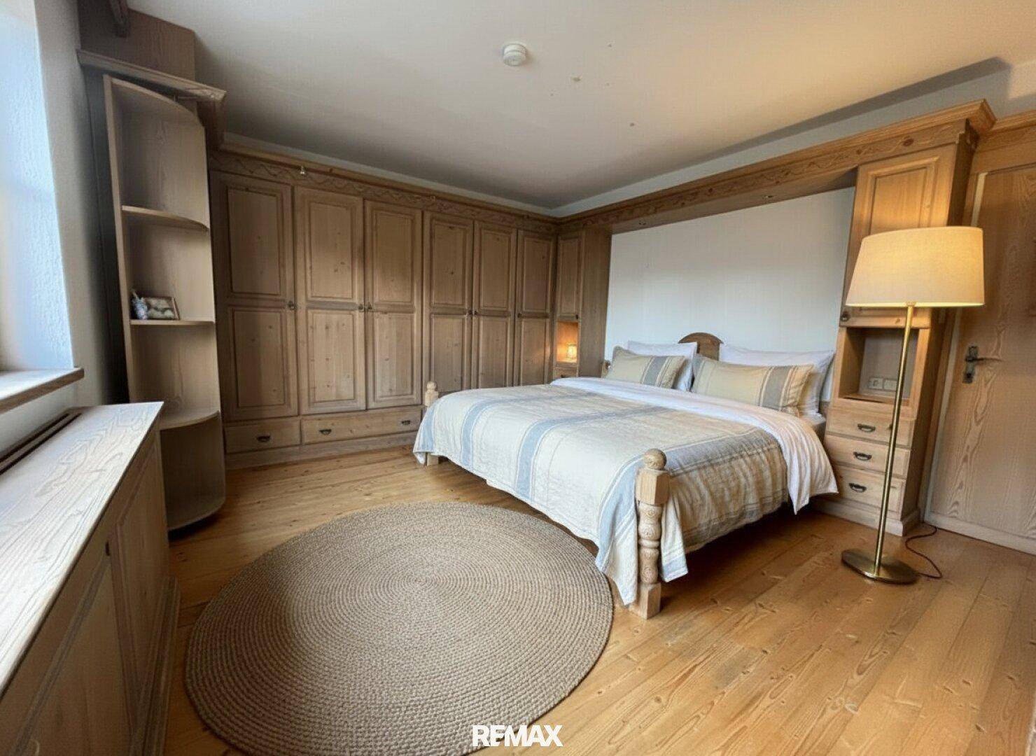 Gemütliches Schlafzimmer mit Holzboden, Einbauschränken und rustikalen Holzmöbeln.