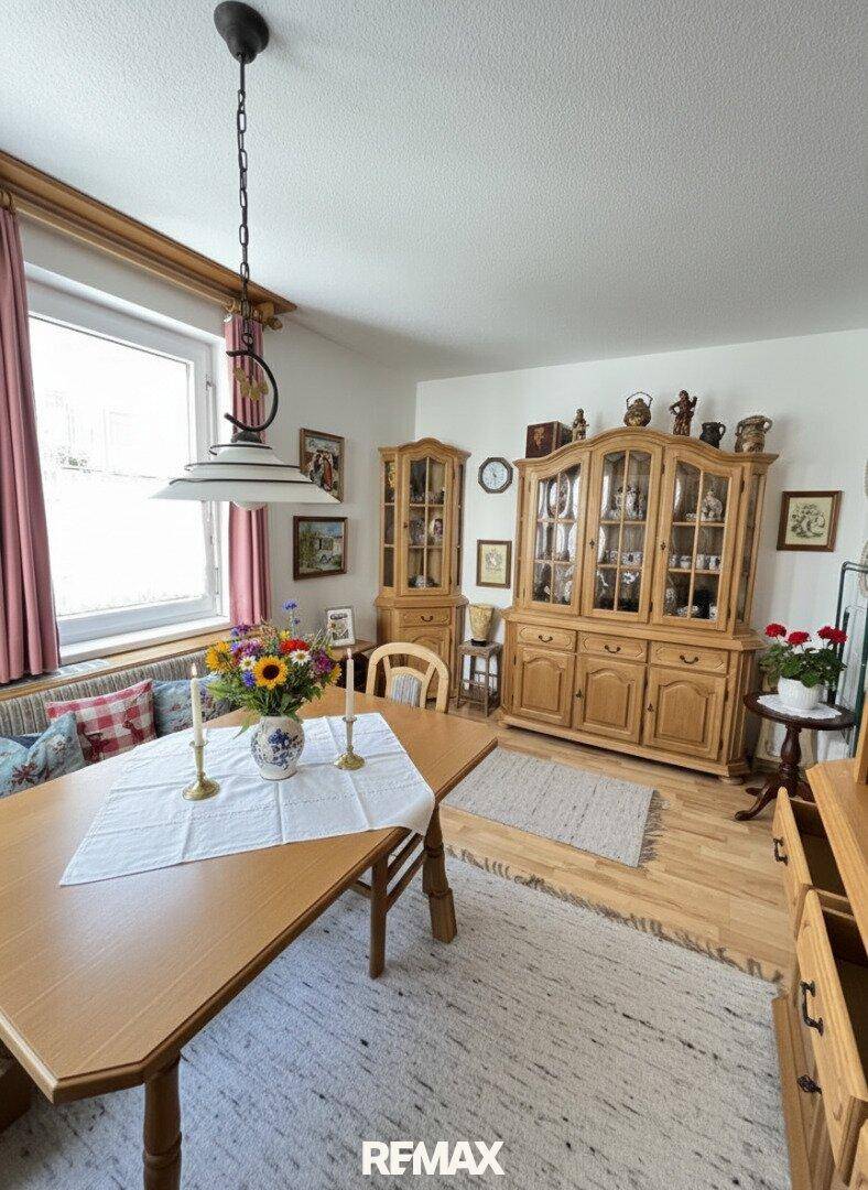 Traditioneller Essbereich mit Holztisch, Vitrinenschränken und gemütlicher Sitzecke am Fenster.