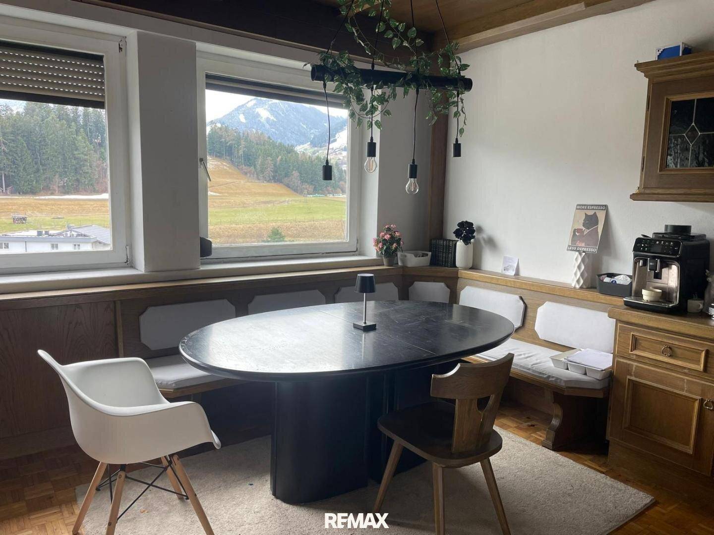 Gemütlicher Essbereich mit Holztäfelung, Bergblick und modernem Esstisch.