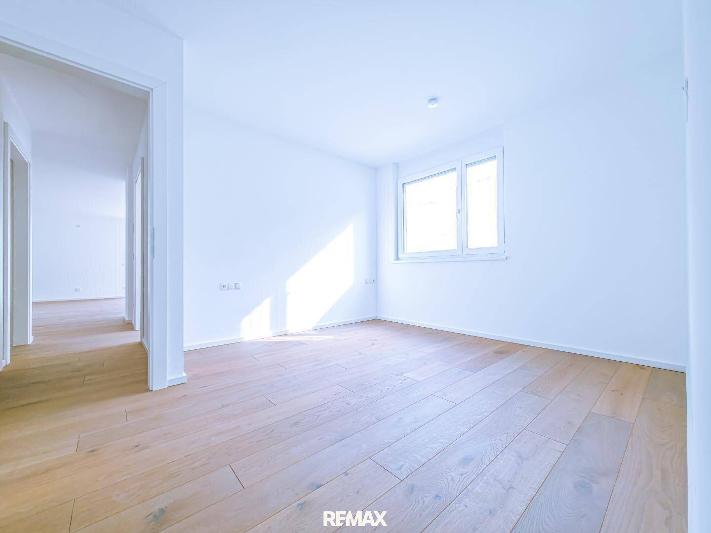 Heller Raum mit Holzboden und Fenster, ideal als Schlafzimmer oder Kinderzimmer nutzbar.