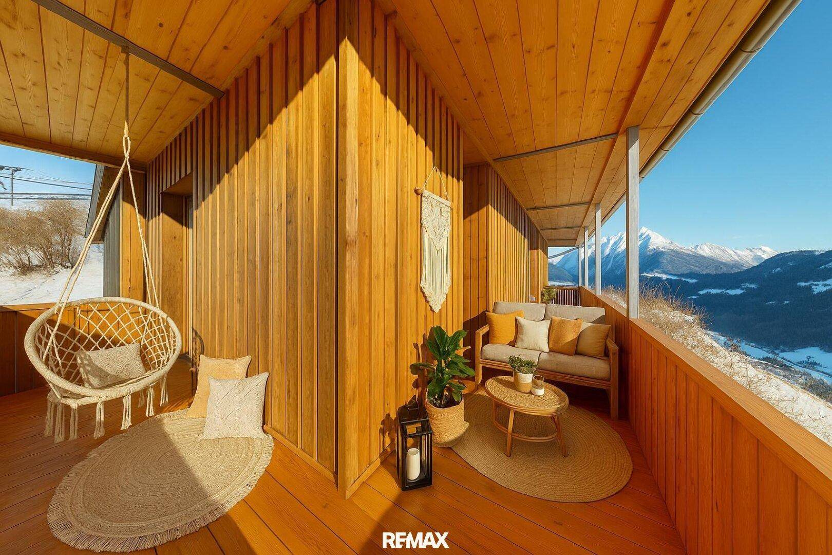 Sonnige Holz-Loggia mit gemütlichen Outdoor-Möbeln und weitem Blick auf die Berge.