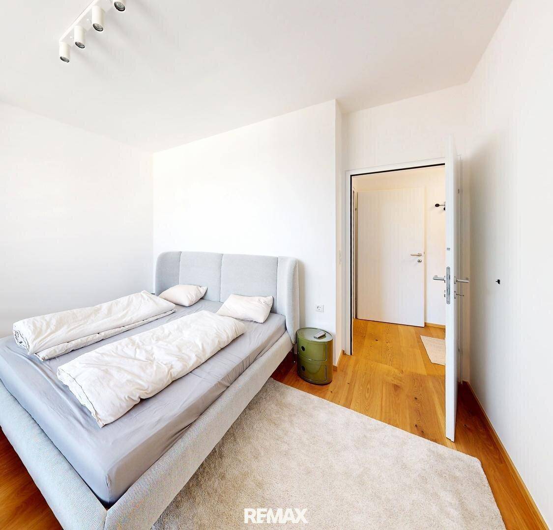 Helles Schlafzimmer mit Holzboden und einem bequemen Doppelbett, das eine ruhige Atmosphäre schafft.