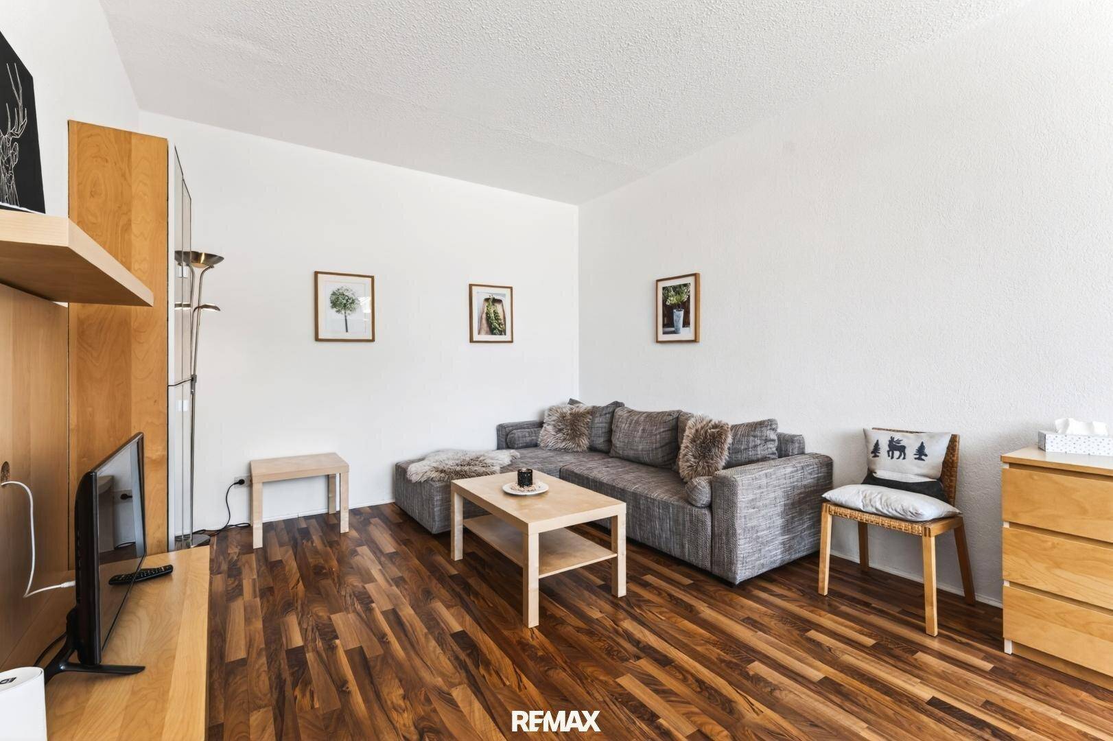 Helles Wohnzimmer mit komfortabler Sitzecke, Holzboden und moderner Dekoration.
