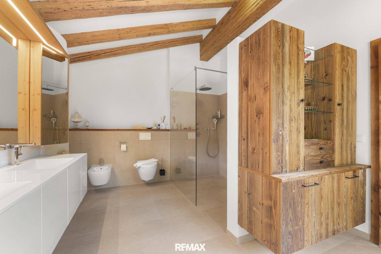 Geräumiges Badezimmer mit begehbarer Dusche, Doppelwaschbecken und rustikalen Holzmöbeln.