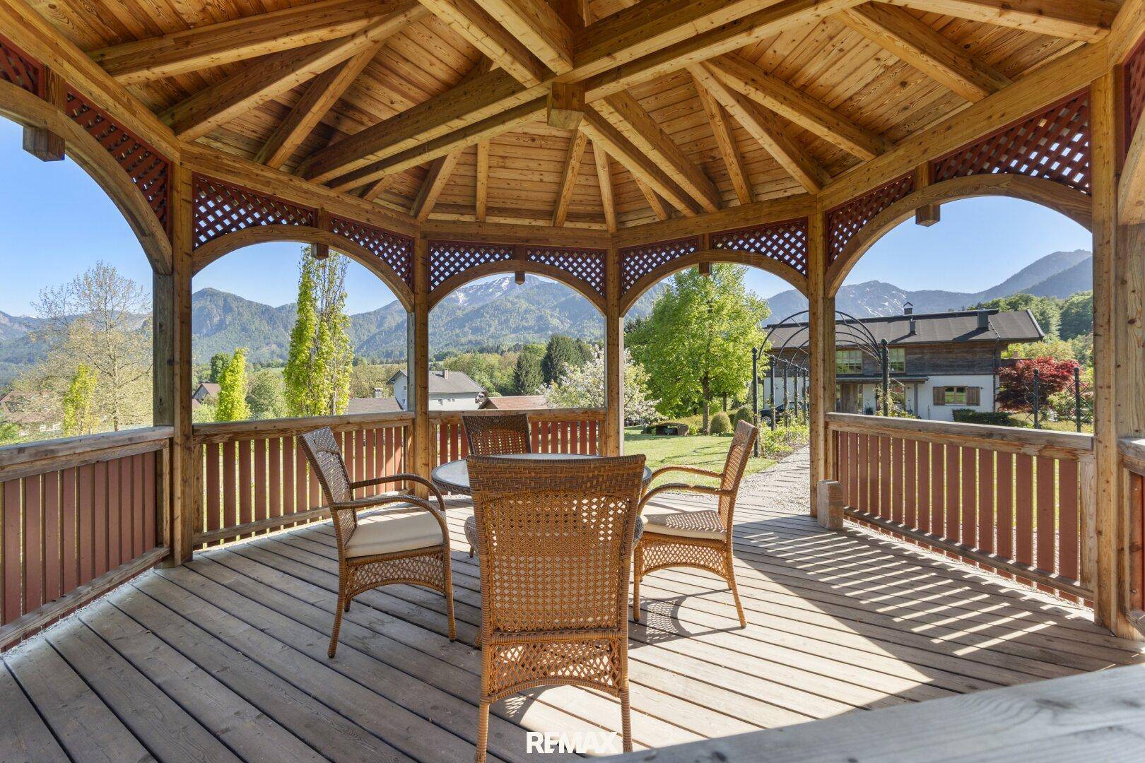Gemütlicher Holzpavillon mit Sitzgelegenheiten und weitem Blick auf die umliegende Berglandschaft.