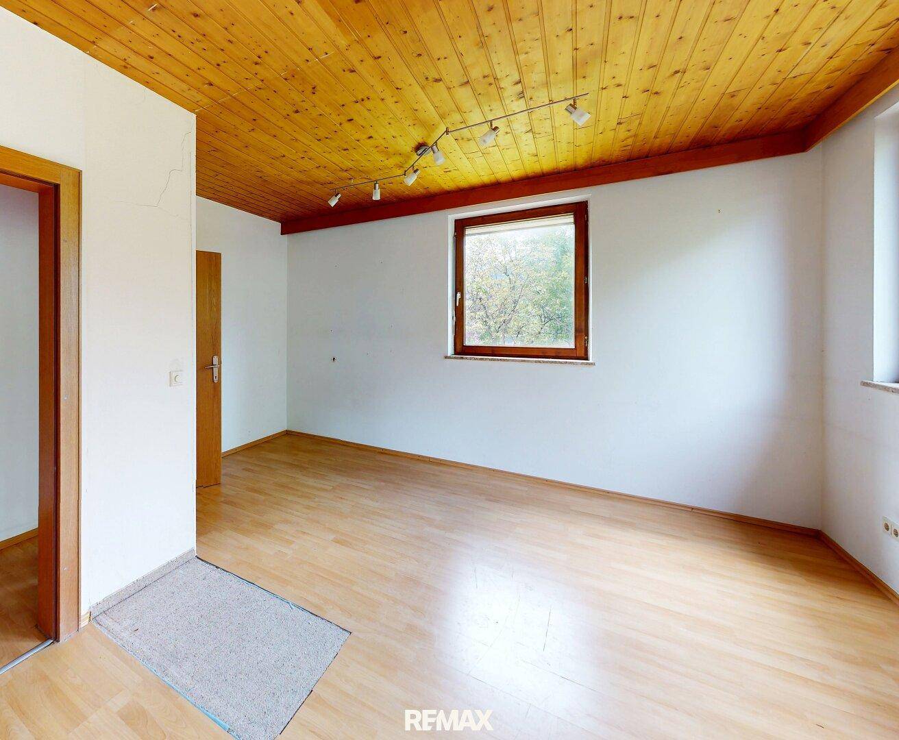 Leerer Raum mit Holzboden und Holzdecke, bereit zur individuellen Gestaltung.