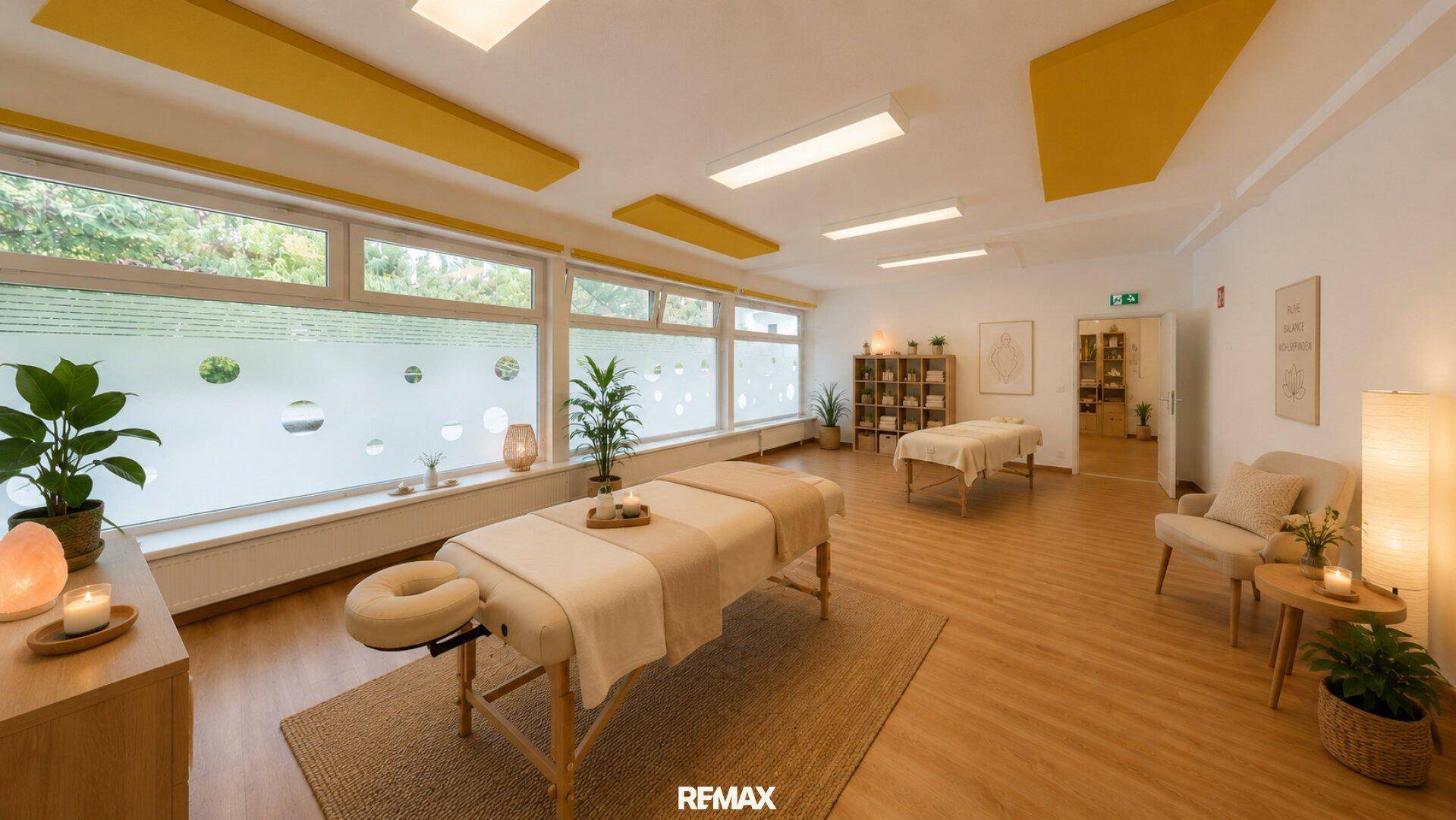 Beruhigender Therapieraum mit zwei Massageliegen, Pflanzen und großen Fenstern mit Sichtschutz.