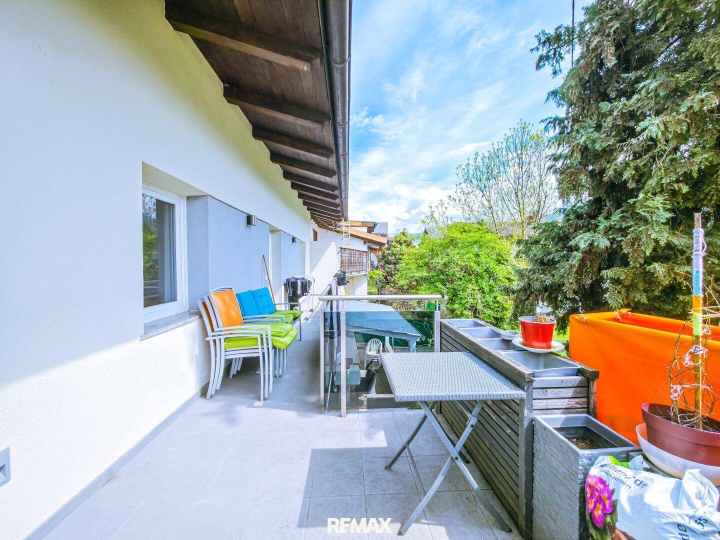 Balkon mit Gartenmöbeln und Pflanzen, bietet eine grüne Aussicht und Bergblick.