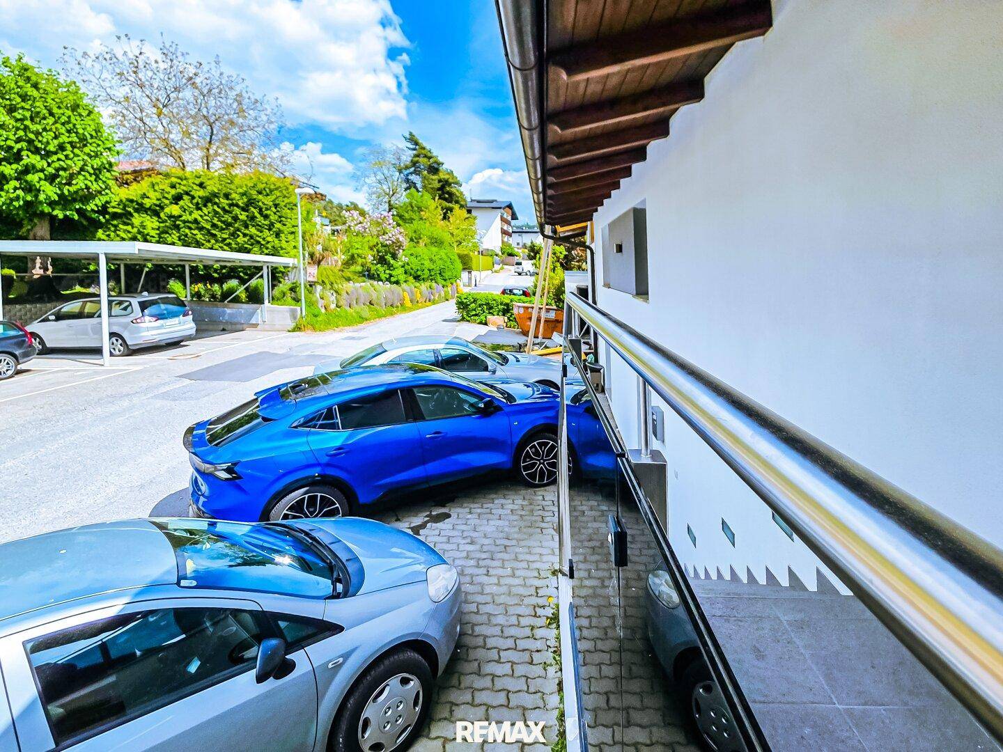 Außenansicht des Gebäudes mit Parkplätzen und Carports für Fahrzeuge.