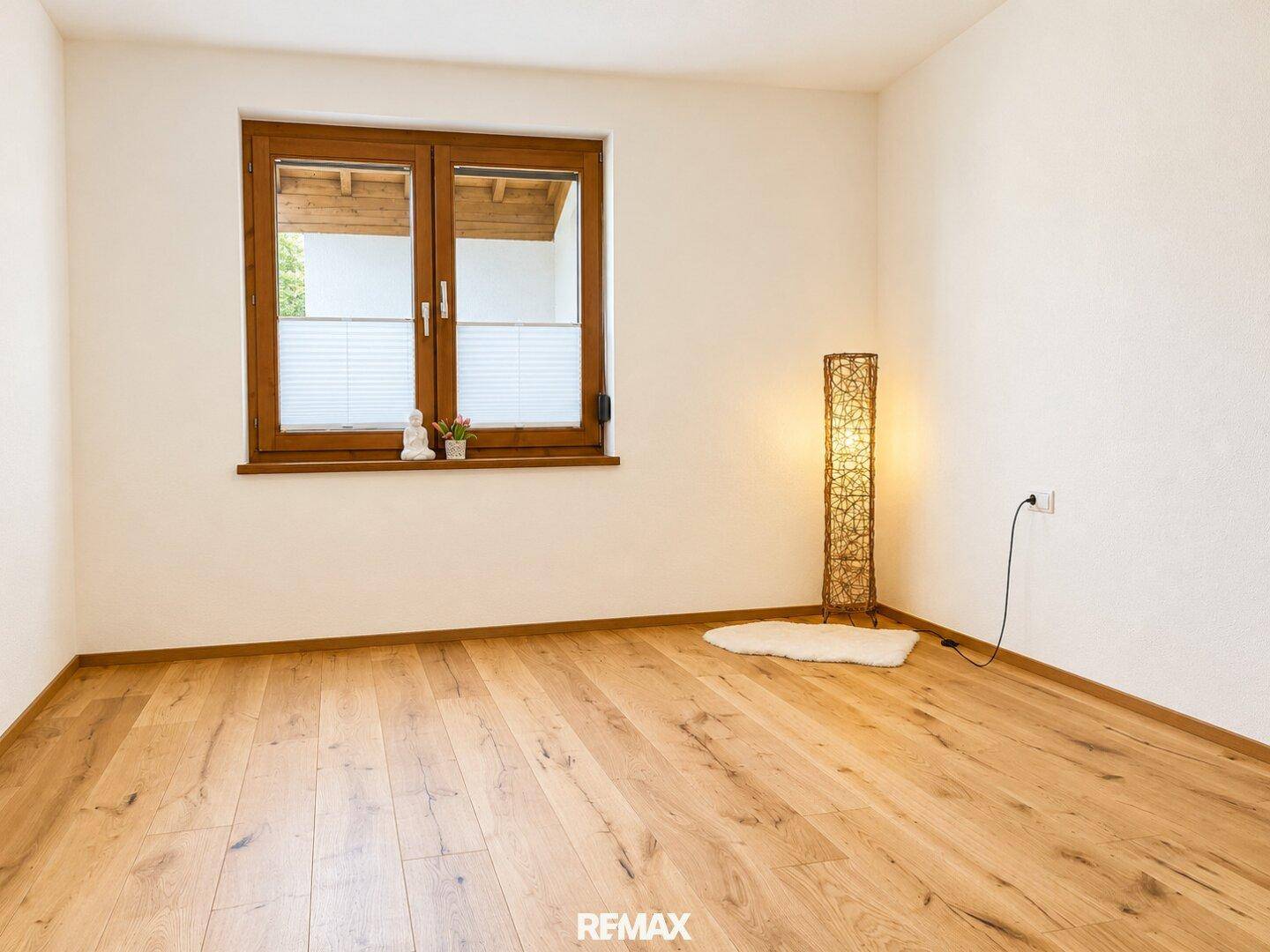 Ruhiges Zimmer mit Holzboden und einem Fenster, das eine angenehme Atmosphäre schafft.