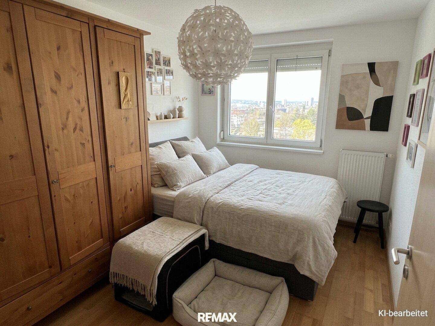 Helles Schlafzimmer mit Holzboden, großem Fenster und einem geräumigen Holzschrank.