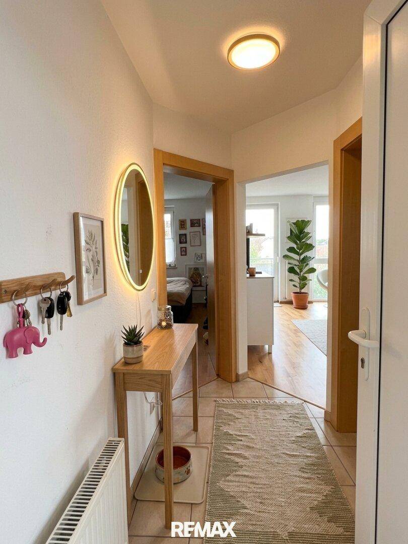Heller Eingangsbereich mit Fliesenboden, modernem Spiegel und praktischer Garderobe.