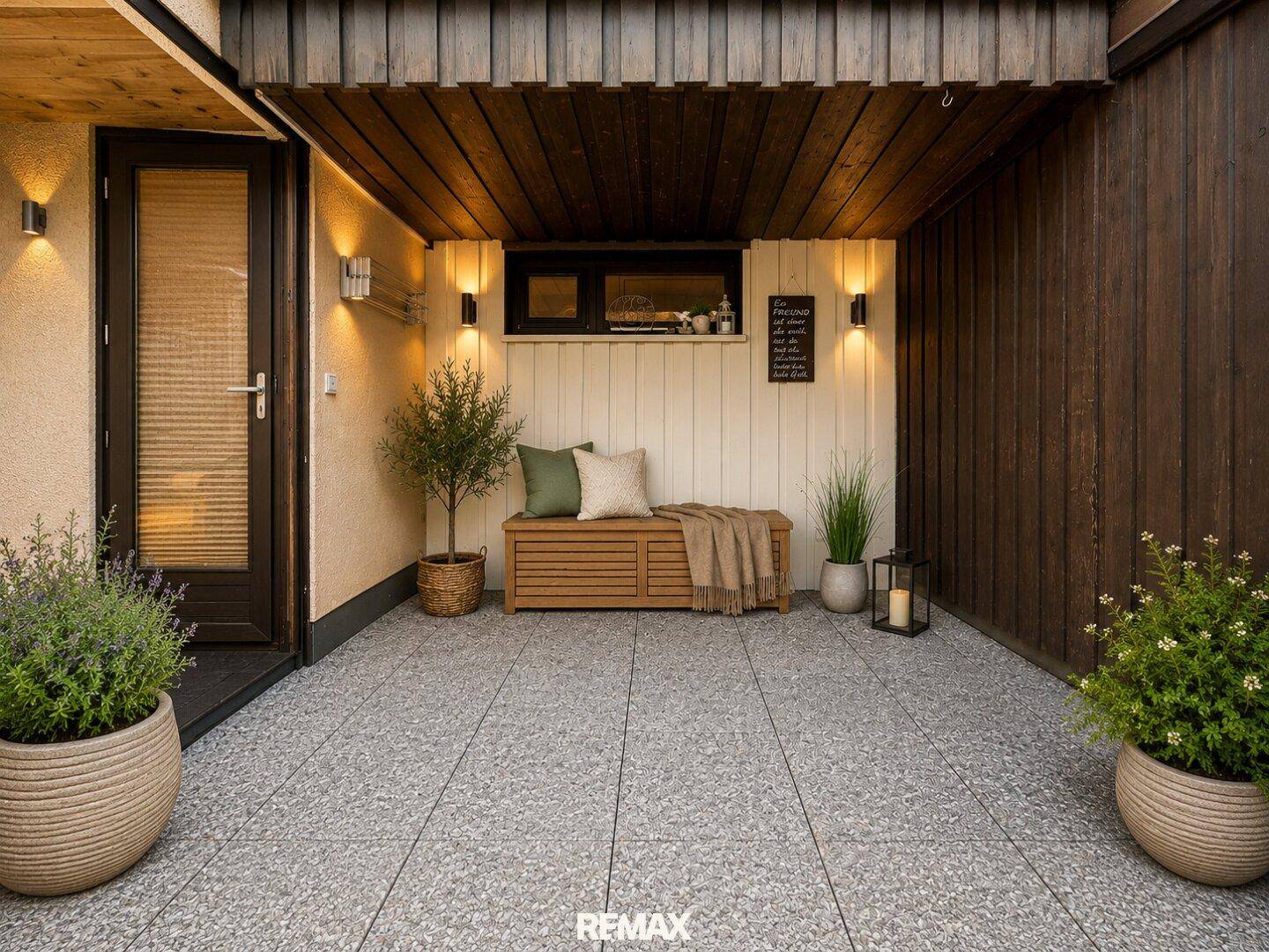 Überdachte Terrasse mit Fliesenboden, Holzbänken und stimmungsvoller Beleuchtung.