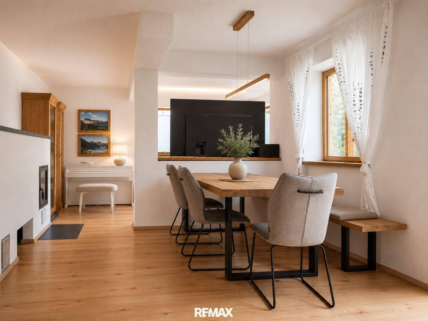 Heller Essbereich mit Holztisch, modernen Stühlen und Blick in den Wohnbereich.