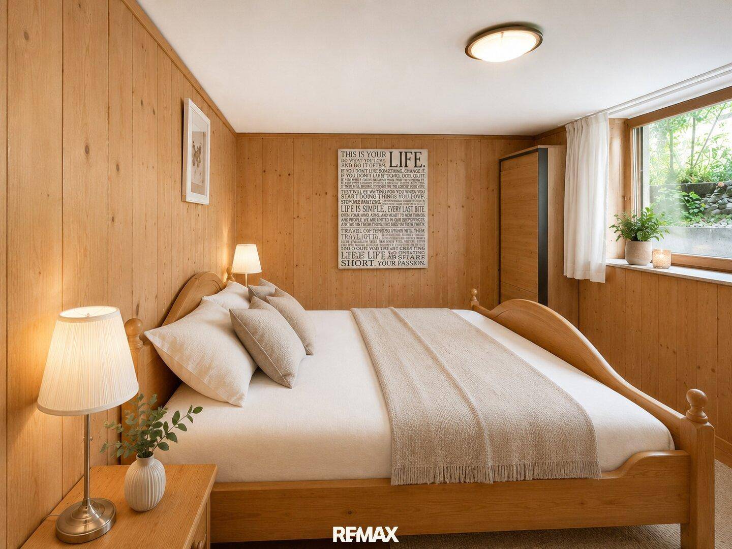 Gemütliches Schlafzimmer mit Holzvertäfelung, Doppelbett und Fenster zum Garten.