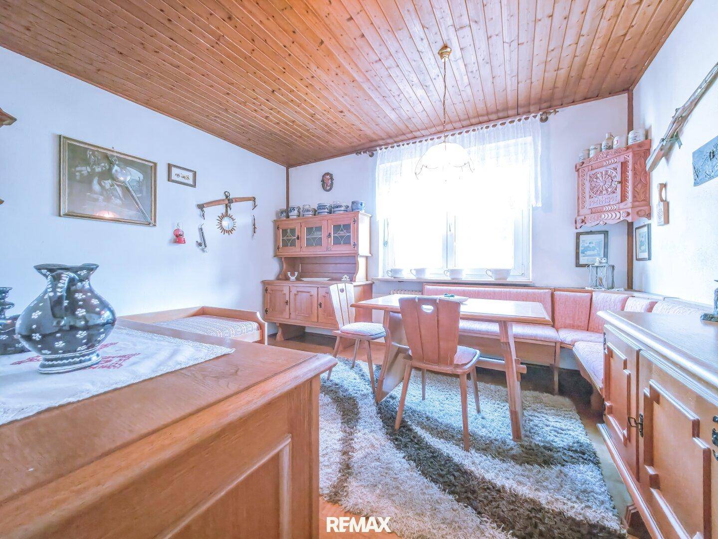 Gemütlicher Essbereich mit Holztisch, Eckbank und Blick auf die grüne Umgebung.