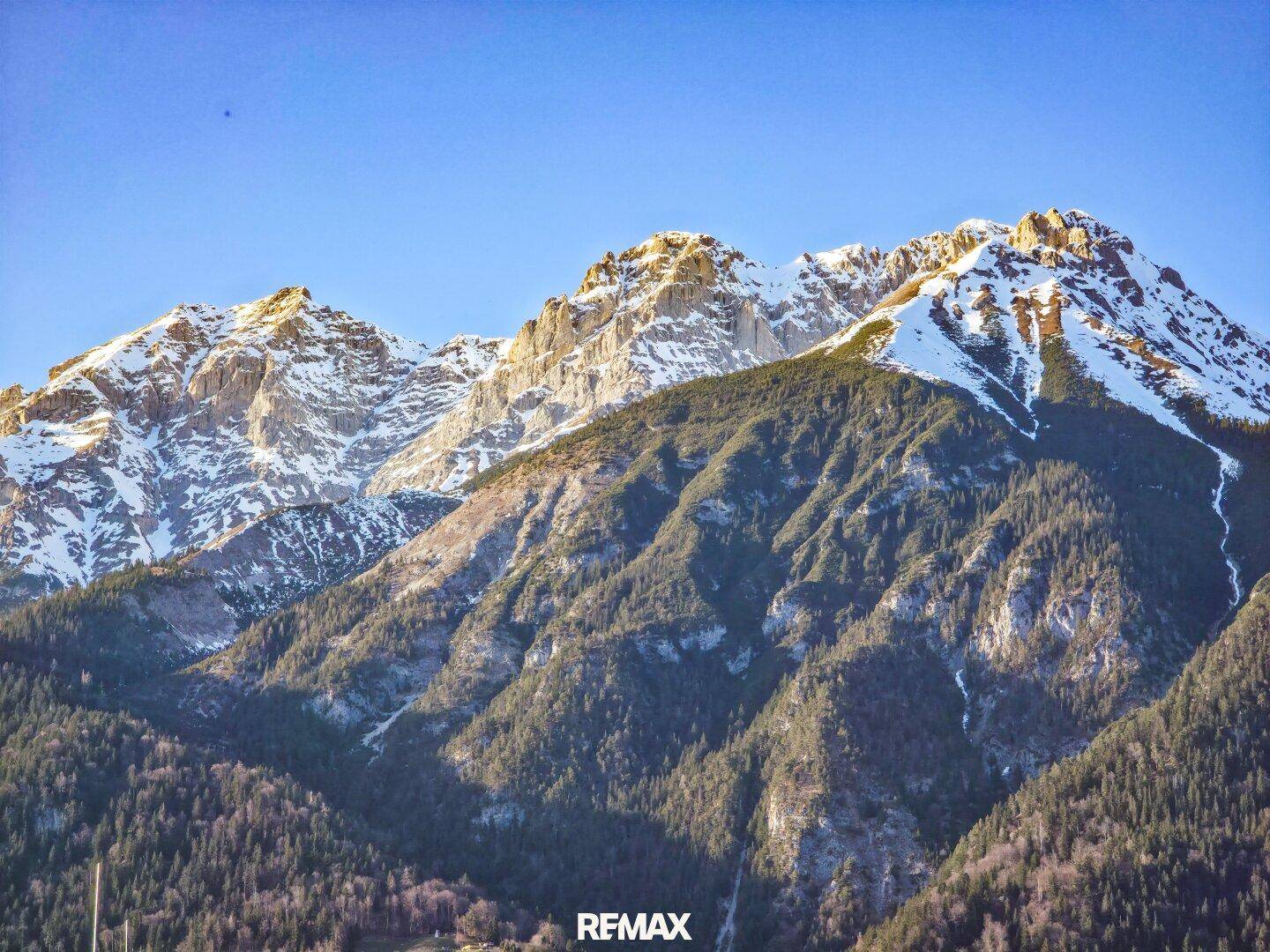 Majestätische schneebedeckte Berge unter einem klaren blauen Himmel.
